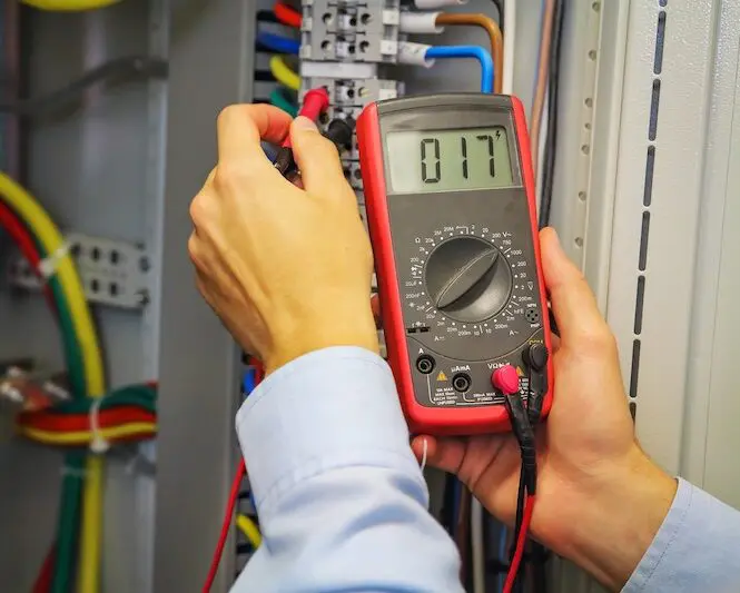 Electrician using multimeter on wires