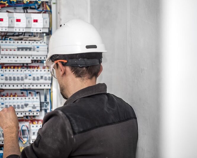 Electrician working on circuit panel
